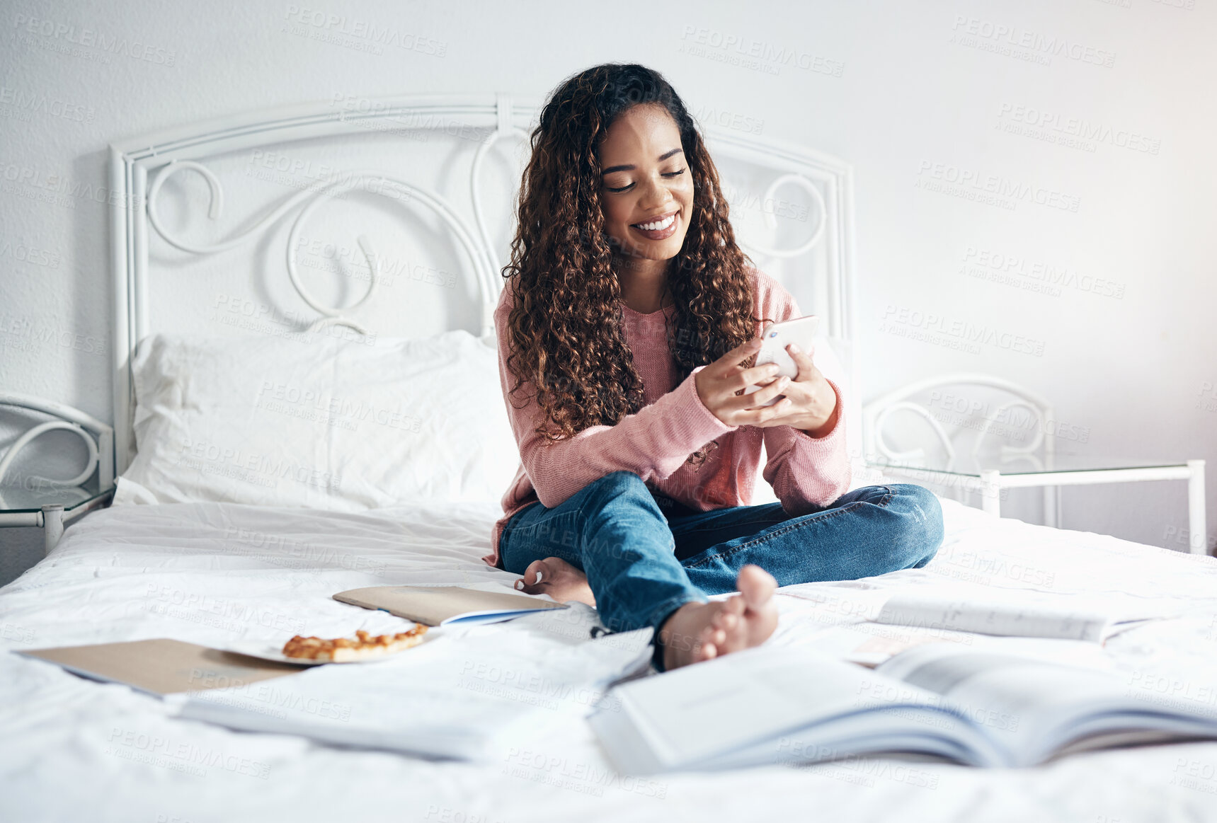 Buy stock photo Phone, books and relax woman student break from learning, studying and education exam paper in bed. University or college girl rest with mobile smartphone for online social media and smile at post