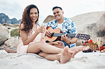 Couple, beach and guitar for music and love on picnic together on sand by ocean. Man, woman and smile with happiness on face with food, champagne and flowers to relax, vacation and travel in summer