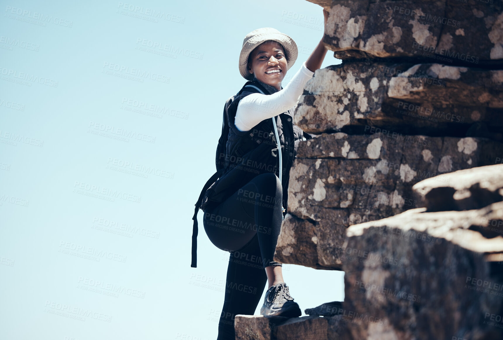 Buy stock photo Black woman, climbing a rock mountain and adventure in nature for healthy exercise or sport workout. African American female in sports fitness with smile for summer rocky climb in South Africa