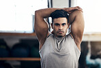 Health, young man and wellness training, stretching and happy in gym for workout, fitness and cardio. Portrait, Indian male and athlete being confident, relax and doing healthy warm up for exercise.