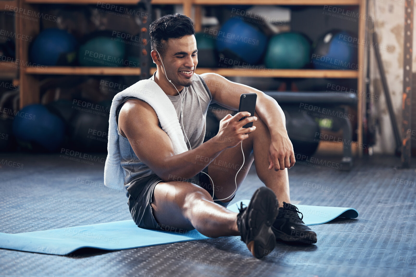 Buy stock photo Man, exercise and phone on social media with smile rest on floor in gym during training session. Guy, wellness and smartphone take break during workout for fitness, health and sport with happiness