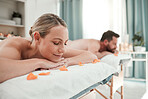 Spa, massage and couple relax in luxury treatment for health, wellness and therapy session at a resort. Man and woman enjoying a calm day of zen, care and relaxation lying on a table for vacation