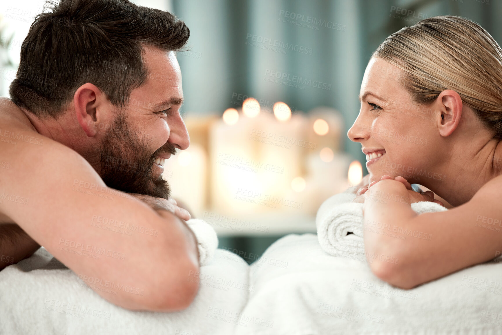 Buy stock photo Spa, smile and couple on massage bed table for luxury messaging, relax and zen on holiday in hotel resort. Wellness, happy man and woman looking into eyes in body care treatment or vacation together.