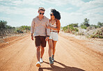 Couple, sunglasses and walking on dirt road in nature on holiday, vacation or summer safari trip. Diversity, love and man, woman and travel outdoors, talking and bonding or spending time together.