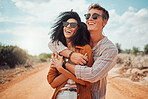 Happy couple, hug and love, smile and travel on roadtrip to the outback of Australia. Adventure, fun and happiness for quality summer vacation time, boyfriend and girlfriend on a desert road. 