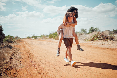 Buy stock photo Couple, love and travel with a man and woman walking on a sand road in the dessert or nature together. Summer, romance and dating with a happy, young male giving a piggyback to a female in the wild