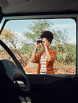 Road trip, travel and binoculars with a sightseeing woman outdoor in nature for a summer vacation or weekend getaway. Freedom, holiday and vehicle with a female standing by her car while traveling