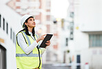 Woman, building manager and construction on tablet doing inspection and working on site in the city. Female architect or builder contractor checking architecture at work on touchscreen technology