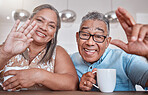 Senior couple, coffee and wave for video call smiling talking or speaking to family at home. Elderly man and woman greeting people on social media or face time while enjoying a warm beverage indoors