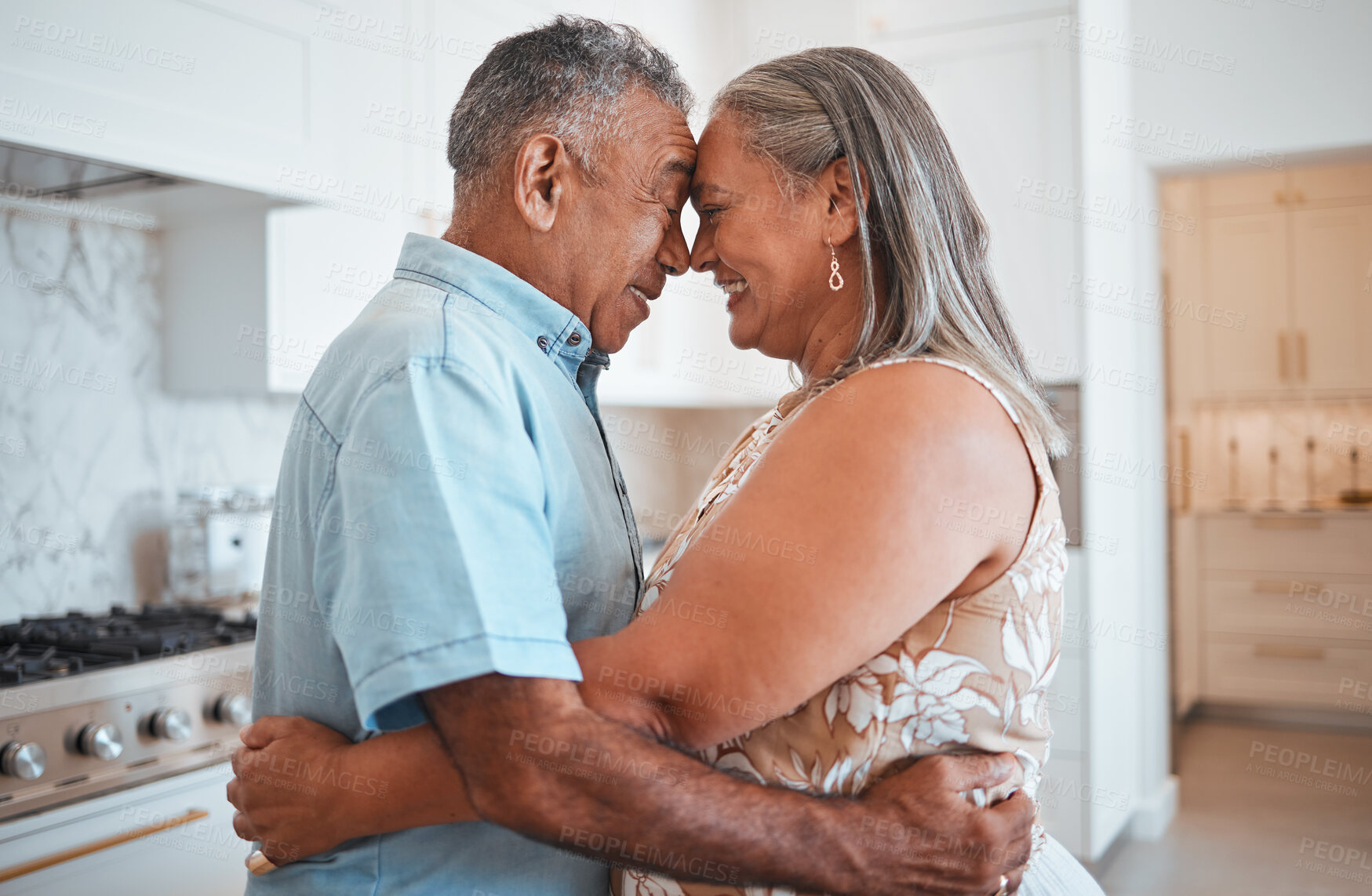 Buy stock photo Hug, love and senior couple with smile for retirement, marriage or support in the kitchen of their house. Happy and elderly man and woman hugging on their anniversary in their home together 