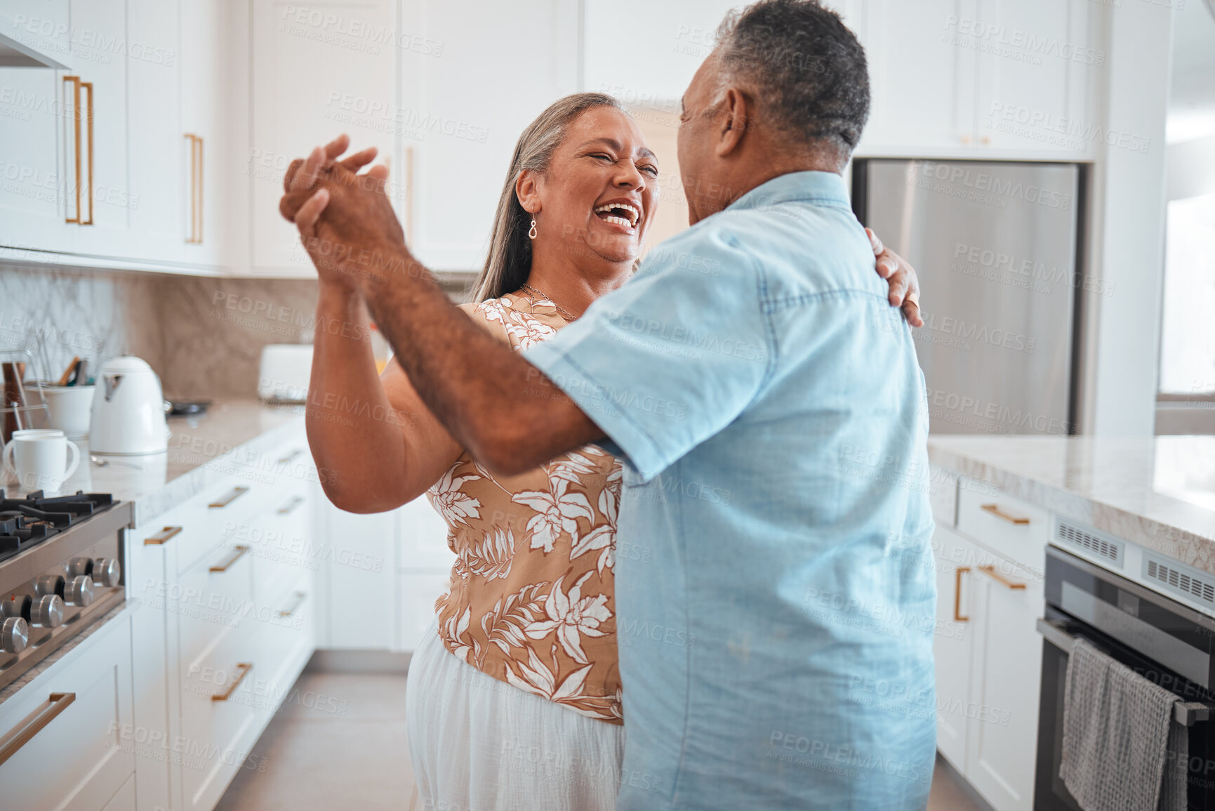 Buy stock photo Happy senior couple, dance and laughing in joyful happiness for relationship bonding in the kitchen at home. Elderly man and woman with smile dancing together for romantic moment in love and care
