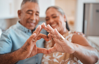 Buy stock photo Hands, heart and love with a senior couple in their retirement home together for health, wellness and romance. Fingers, sign and affection with a mature man and woman pensioner bonding in their house
