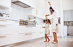 Dance, playful child and mother being comic, crazy and free with a girl in the kitchen together at home. Care, love and happy kid dancing with her mom in freedom while listening to music in house