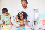 Family, children and baking with a girl and boy learning about cooking with their father in the kitchen of their home. Kids, food and love with a man teaching his son and daughter how to bake