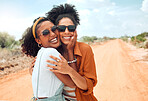 Adventure, road trip and portrait of friends in the desert smiling on dirt road. Travel, summer and happy black women couple hug in countryside with smile on faces, sunglasses and freedom on vacation