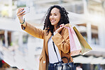 Fashion, shopping and woman taking a selfie in the city standing in the street. Black woman with shopping bags, phone in hand and taking a picture in retail shopping mall, happy from sale or discount