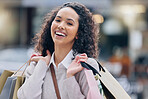 Black woman while shopping and happy with retail fashion brands at urban outdoor mall. Young customer smile in portrait, shop bags from designer clothes store for sale, discount and bargain.