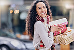 Shopping, christmas and retail with a black woman customer holding a gift or present outdoor in the city. Celebration, holiday and happy with a young female consumer at an outdoor mall or store