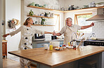 Senior couple, dance in kitchen and smile with love while making pancake breakfast in family home. Happy old man, dancing with smiling elderly woman and fun in retirement together while cooking food 