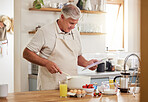 Cooking, recipe and senior man with a video online for breakfast in the kitchen of his house. Elderly man reading information about food for healthy and vegan lunch on the internet with a tablet