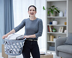 House work, laundry and a woman with basket with clothes, housekeeping and smile in living room. Happiness, cleaning and washing, a happy modern housewife doing household chores at home in Ukraine. 