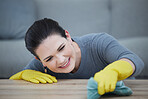 Portrait of woman with gloves, cleaning the table and wipe stain on furniture. Washing, clean and girl doing domestic chores in living room with cloth for dust, dirt and bacteria with rubber gloves
