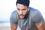 Man exhausted during fitness workout, muscular and running exercise routine for health and wellness. Earphone, endurance, and cardio training, young person working out and breathing control. 
