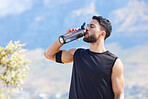 Fitness, blue sky and man drinking water from bottle to refresh and relax after workout, running or sports training. Cardio runner, exercise and thirsty young person with liquid drink for hydration