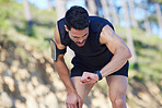 Exercise, watch and time with a sports man tracking his fitness on a sport app while running outdoor in nature. Training, workout and health with a male athlete timing his run, speed or distance