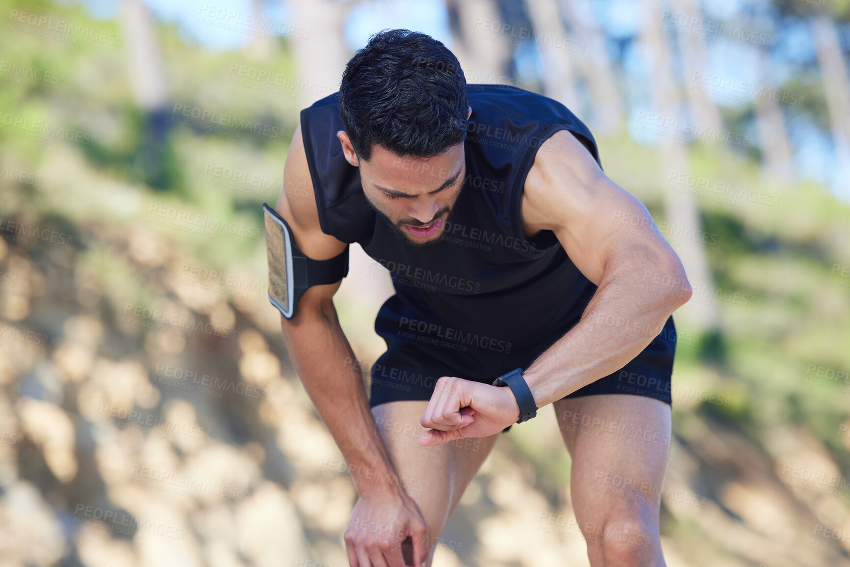 Buy stock photo Exercise, watch and time with a sports man tracking his fitness on a sport app while running outdoor in nature. Training, workout and health with a male athlete timing his run, speed or distance