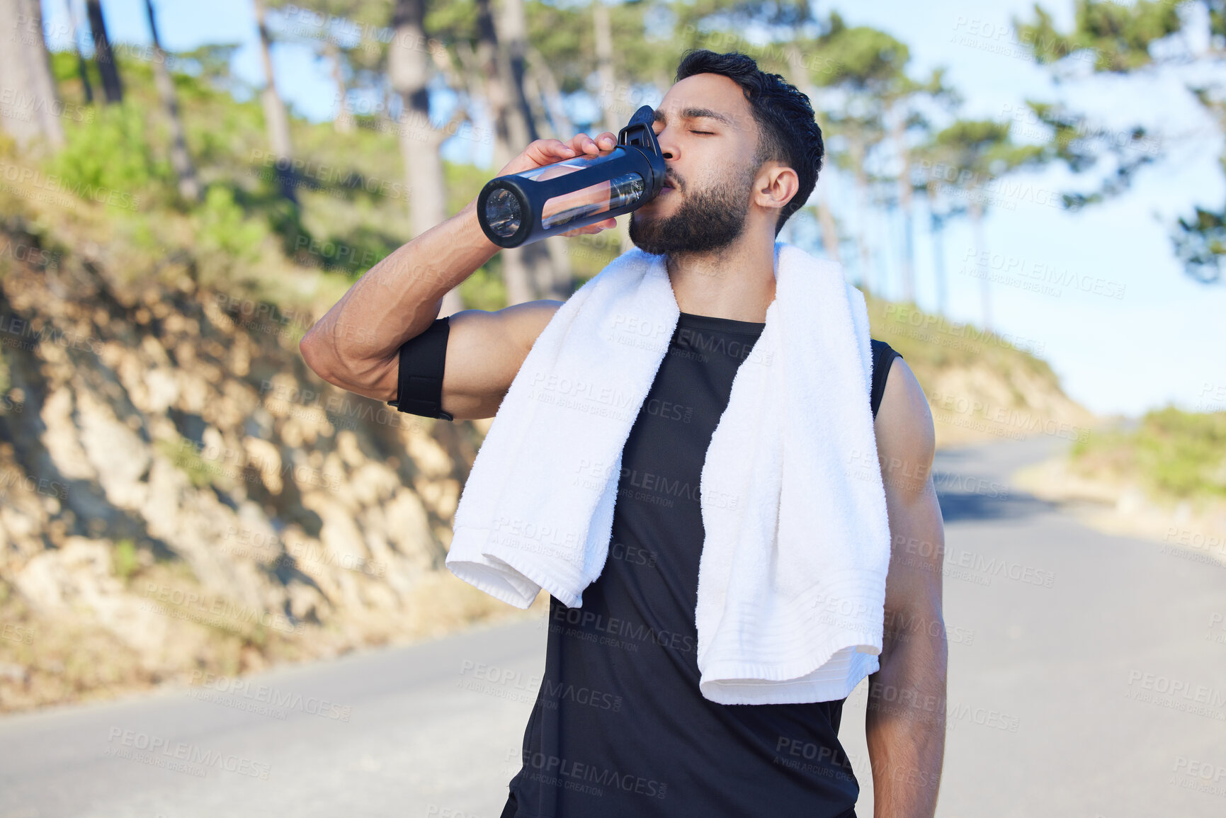 Buy stock photo Water, fitness and exercise with a sports man drinking from a bottle for hydration during his workout or training routine. Health, wellness and rest with a male athlete taking a break from a routine