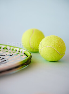 Sport, tennis ball and racket in an empty studio on a gray background for sports, fitness and exercise. Training, workout and health with still life equipment on the floor ready for a game or match