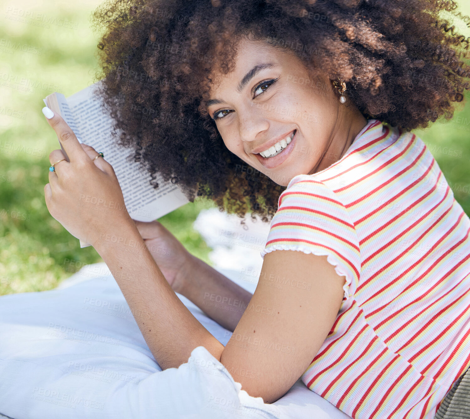 Buy stock photo Smile with book, reading and black woman in the park for a picnic with a blanket outdoors in nature portrait. Happy, young person relaxing and hobbies, learning on a break on the weekend in spring.