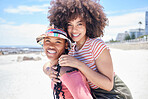 Piggyback, travel and friends on holiday at the beach in Miami during summer together.  Portrait of smile, relax and African women being playful by the sea, ocean or water in nature on vacation 