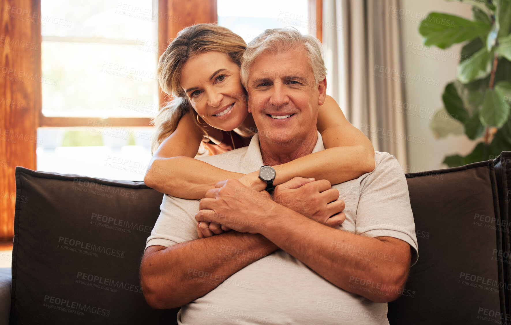 Buy stock photo Happy senior couple, hug and relax for love, care and bonding time with smile at home on living room sofa. Portrait of elderly man and woman in relationship happiness hugging and relaxing on couch