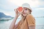 Grapefruit, wellness and woman on tropical beach for nature holiday, vacation or outdoor vitamin c health. Vegan, youth lifestyle for skin care, detox or healthy eating with sky mockup and sea water