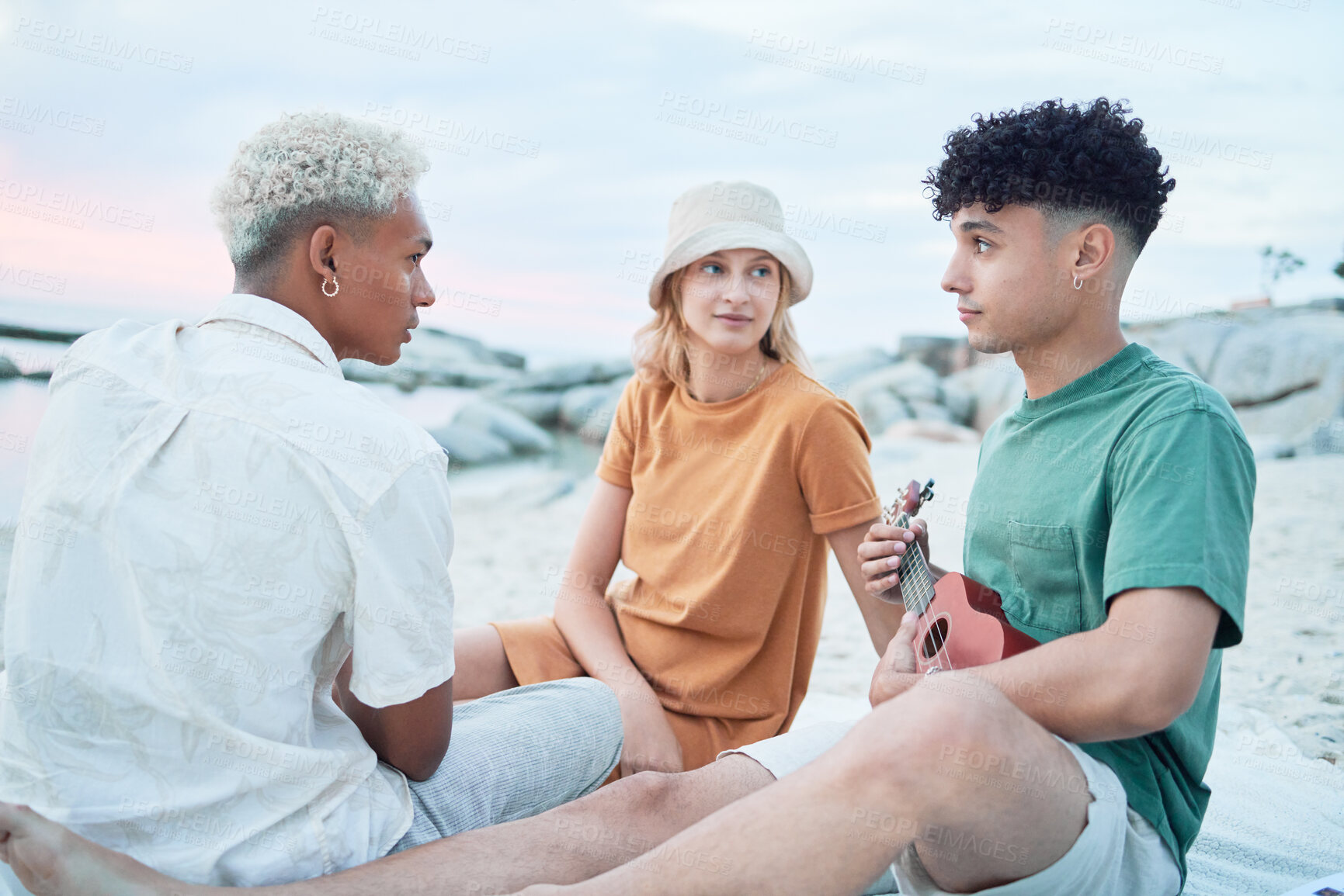 Buy stock photo Guitar, beach and friends on holiday at the sea in Spain with music from a musician for peace and calm in nature. People listening to sound from playing ukulele during vacation for travel by ocean