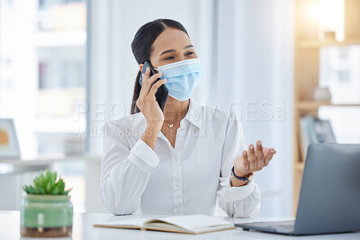 Buy stock photo Covid, phone call and mask with a business woman at work in an office on laptop and talking on a phone. Mobile, communication or networking with a young female employee remote working alone at a desk