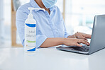 Covid, hand sanitizer and a woman typing on laptop with face mask in office. Online work, hygiene and businesswoman with alcohol spray on desk. Virus prevention, safety and cleaning hands in pandemic