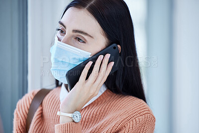 Buy stock photo Woman, covid and mask on a phone call by window looking out at home for safety and quarantine indoors. Young female wearing protective face masks during pandemic and calling consultant on smartphone