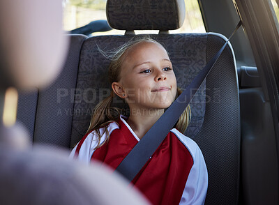 Buy stock photo Girl child, road trip and seatbelt in car while smiling looking out the window on journey to sports match. Safety, smile and happy kid passenger on fun travel trip with transportation in Australia