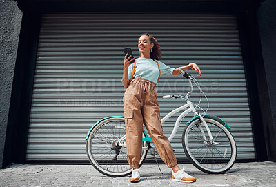 Buy stock photo Bicycle, phone and black woman in city, street or urban road outdoors. Bike, travel and happy female from South Africa on 5g mobile tech, internet browsing or social media, web or online surfing.
