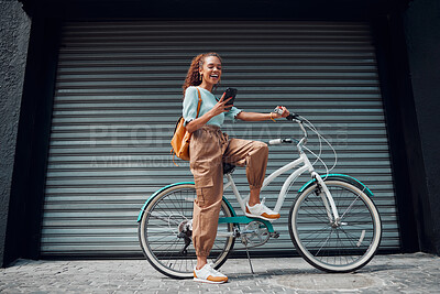 Buy stock photo Bicycle, woman and phone in city feeling excited and happy about message while outdoor in summer with trendy look. Eco friendly transportation for carbon footprint female on a bike using 5g network