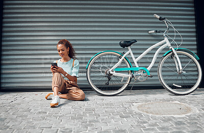 Buy stock photo Bike, young woman and with phone in city relax, with bicycle and happy texting, social media apps and chat. Casual girl, lady and with eco friendly transportation, trendy or edgy look sit on sidewalk