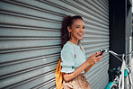Phone, bike and black woman on wall in city, street or urban outdoors. Travel, bicycle and happy student from Nigeria on 5g mobile tech, social media or internet surfing, web browsing or text message
