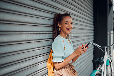 Buy stock photo Phone, bike and black woman on wall in city, street or urban outdoors. Travel, bicycle and happy student from Nigeria on 5g mobile tech, social media or internet surfing, web browsing or text message