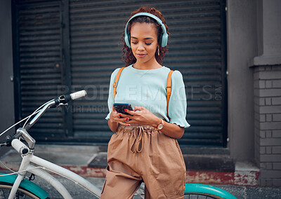 Buy stock photo Phone, music and black woman cycling with a bike in the city of Australia for travel, adventure and to relax. Young, urban and African girl on social media with tech and a podcast riding a bicycle