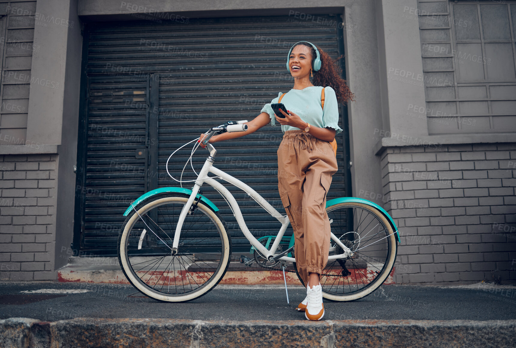 Buy stock photo Bicycle, phone and happy woman with headphones for music while on walk in the city street. Happiness, smile and girl from Puerto Rico listening to audio, podcast or radio on smartphone in urban road.