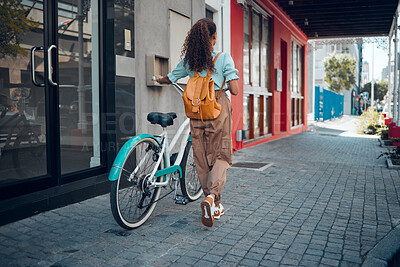 Buy stock photo Bike, city and back view of black woman, walking on street or urban road outdoors. Exercise, fitness and female student on bicycle ride, eco friendly transportation and cycling on asphalt in town.

