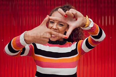 Buy stock photo Happy, black woman and finger frame over eyes for funny face expression on red background. Fashion, comic and positive perspective with female from South Africa with hand gesture feeling playful
